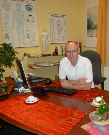 Arzt Dr. med. Bernd Steinig sitzt am Schreibtisch